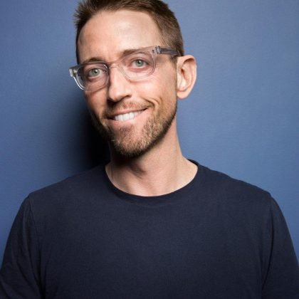 Comedian Neal Brennan smiling in a portrait promoting his upcoming stand-up comedy shows in New York City.