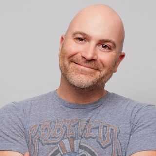 Comedian Mike Finoia performing live on stage in New York City during a stand-up comedy show.