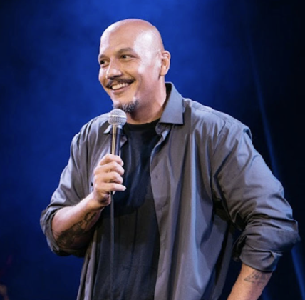 Comedian Luis J. Gomez performing stand-up live on stage in New York City.