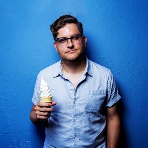 Alex Falcone performing stand-up comedy on stage